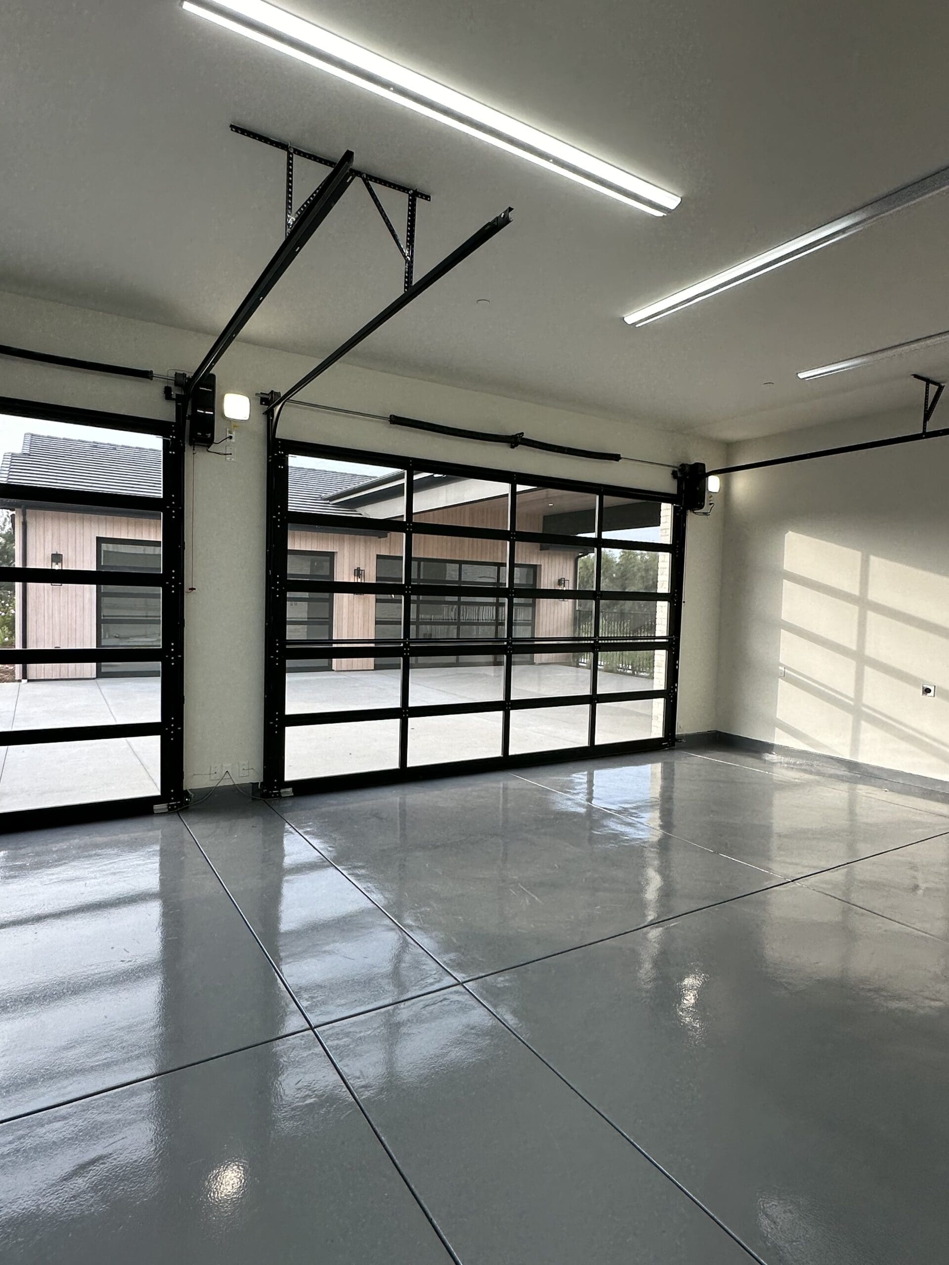 Spacious garage with smart glass doors and modern automation features.